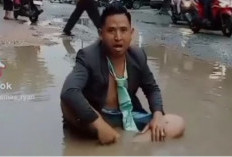 Viral, Protes Jalan Rusak, Pria Berdasi ini Duduk di Kubangan Air di Jalan Berlobang